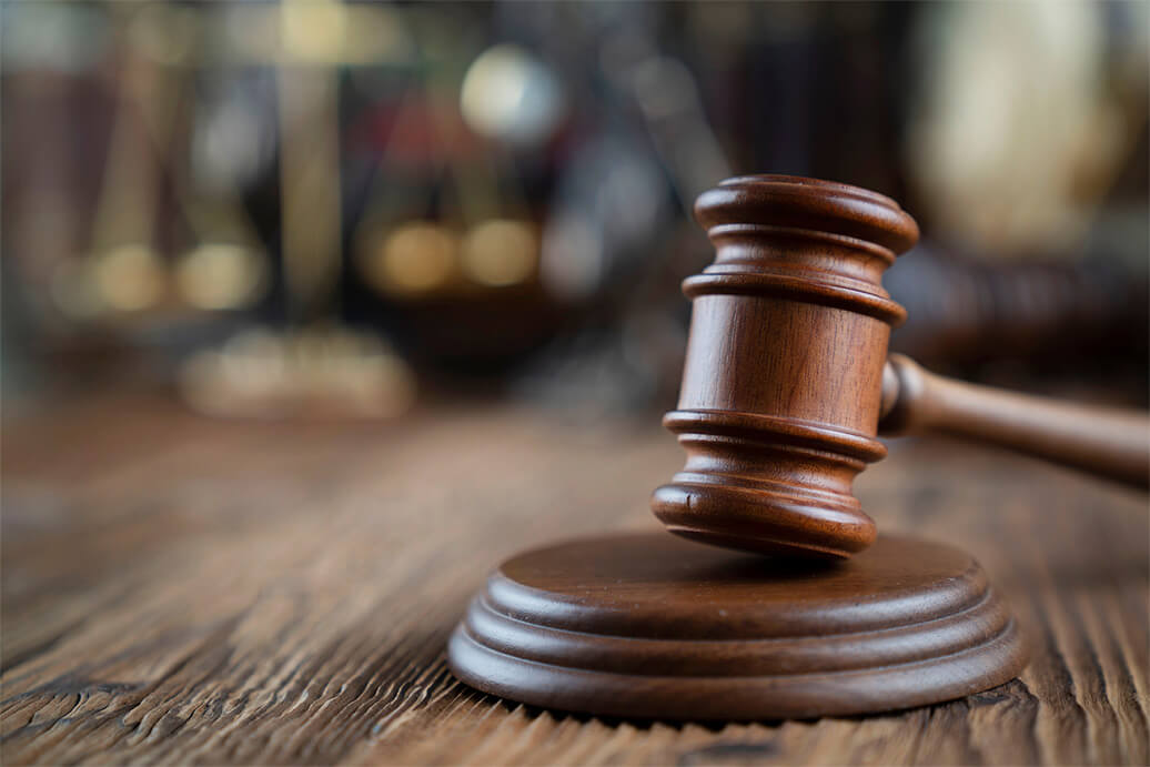 A brown gavel on a wood desk