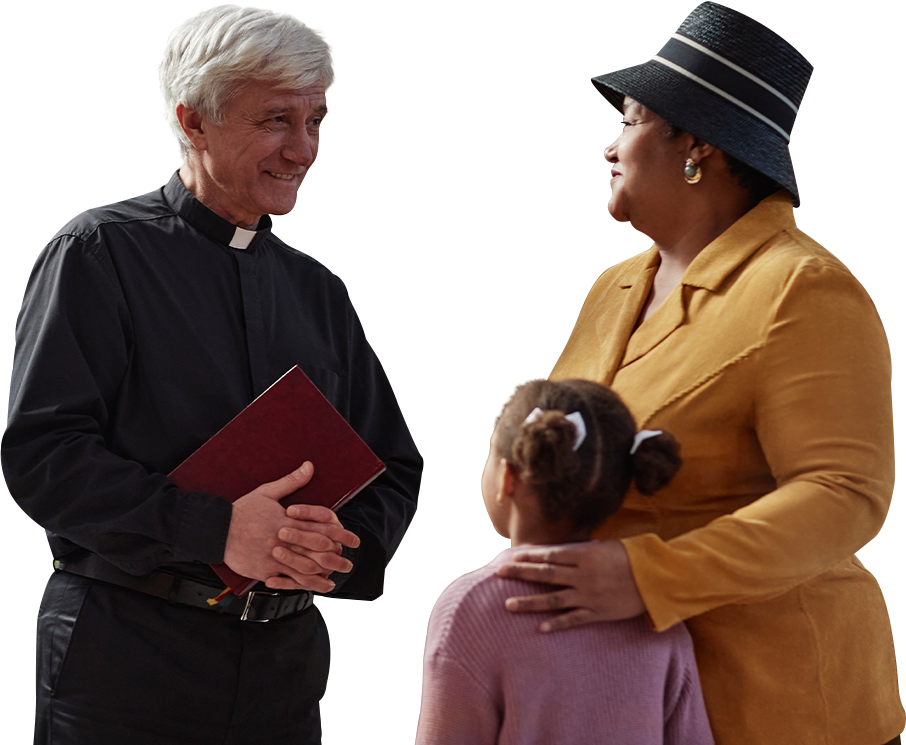 A smiling, friendly priest holding a bible speaking with a woman and her daughter